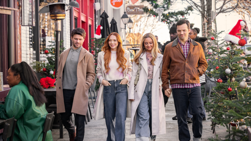 Cast members of 'Our Little Secret,' including Lindsay Lohan and Ian Harding, strolling through a festive, holiday-decorated street, showcasing the cheerful and romantic vibes of the movie.