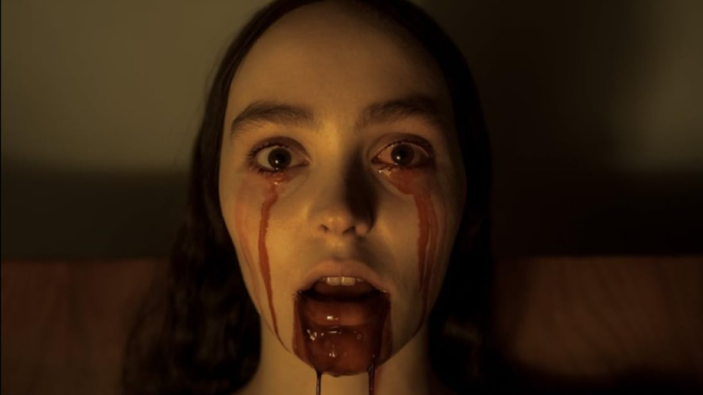 The image features Lily-Rose Depp as Ellen Hutter in the 2024 film Nosferatu, directed by Robert Eggers. In this scene, Ellen's pale complexion and wide, tear-filled eyes convey her deep fear and vulnerability, capturing a pivotal moment in the gothic horror narrative.